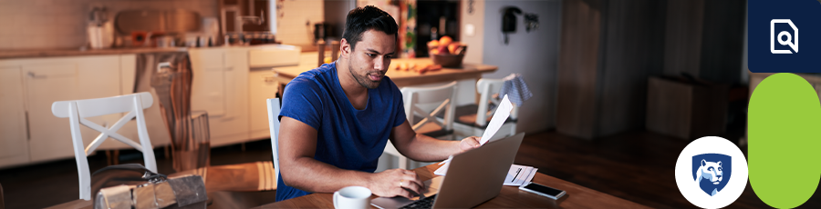 Individual working on a laptop in a home office setting with a smartphone and book nearby. 

